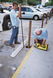 Team members install traffic posts along the ECHO storefront to protect people on the sidewalk from cars.
