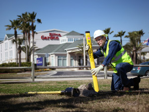 A Peoples Gas team member plants a marker showing where a natural gas line is buried.
